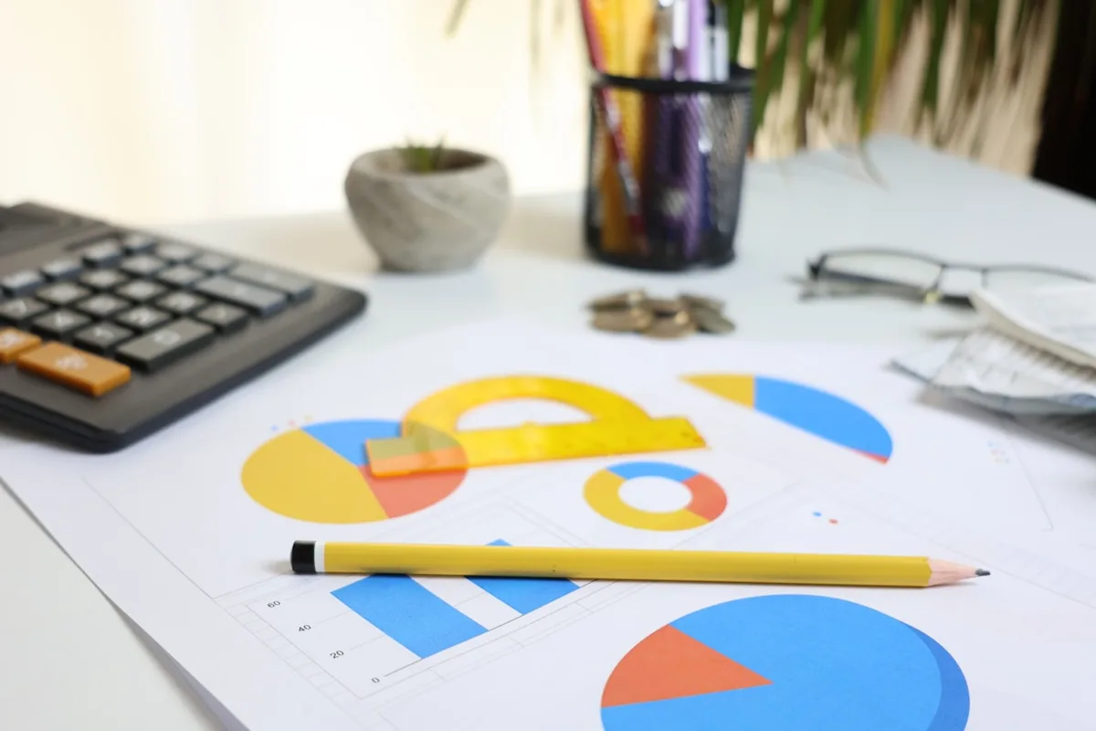 Desk with a calculator, charts and pencil, representing the cost of data entry